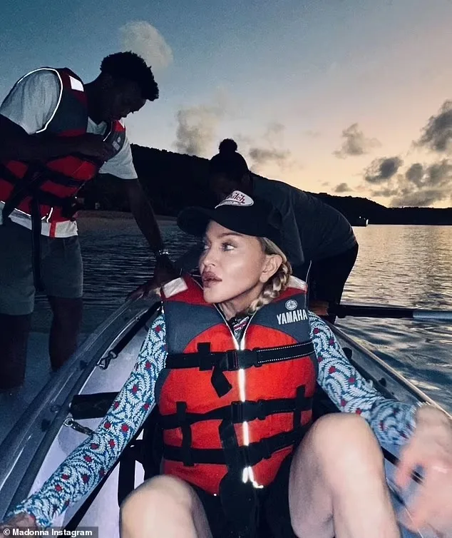 Madonna seated in a clear kayak at dusk in a life vest